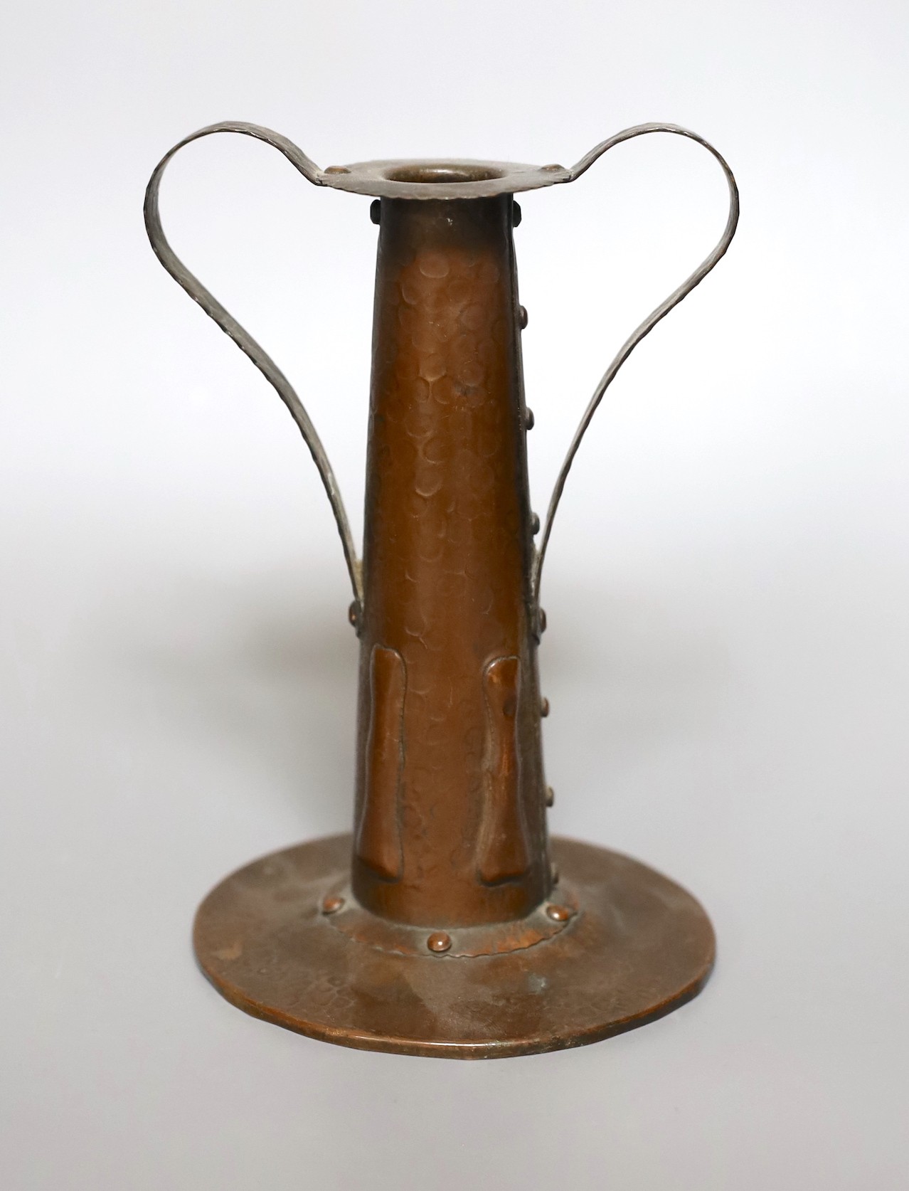 An Arts and Crafts hammered copper candlestick, 18cm tall, and a copper hanging letter rack